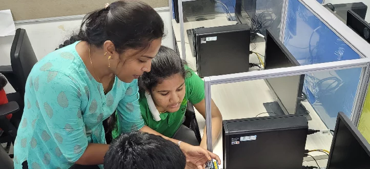 A group of children working on computers in an office.